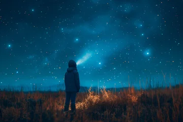 Foto op Plexiglas The boy looks up into the night sky, the evening starry sky. © EUDPic
