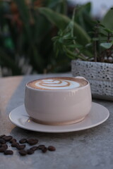 Frothy latte in coffee cup on marble table outdoor