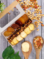 delicious nuts and dried fruits close-up on a wooden background in a box