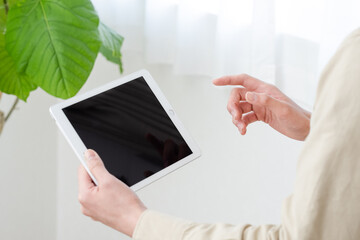 タブレットを操作する男性の手元