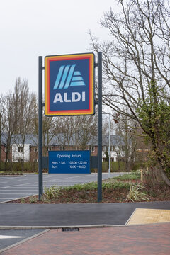 Aldi, Ampthill Rd, Flitwick, Bedford, UK - December 25, 2023: logo and timetable sign at the entrance to the budget-friendly supermarket, popular for very affordable groceries and household essentials