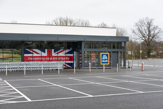 Aldi, Ampthill Rd, Flitwick, Bedford, UK - December 25, 2023: views towards the empty parking lot and the supermarket large windows displaying photo advertisements of this popular discount retailer