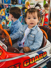 niña subida en una atracción