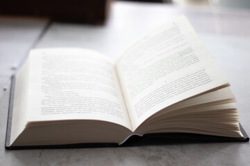 Obraz premium Open book with black cover on the table. Close up view.