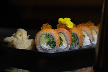 salmon teriyaki sushi roll on black background