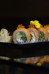 salmon teriyaki sushi roll on black background