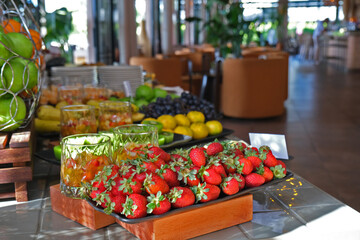 In the open buffet breakfast service, the strawberry plate is in the foreground and other fruit plates are in the background.