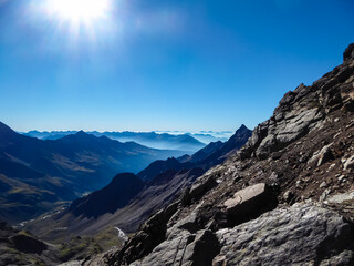 Panoramic view from majestic mountain peak of Hochschober, Schober Group, High Tauern National Park, East Tyrol, Austria. Wanderlust Austrian Alps in summer. Misty rugged ridges against clear blue sky