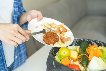 Compost from leftover food, refuse asian young housekeeper woman, girl hand using fork scraping waste from dish, throwing away putting into garbage, trash or bin..Environmentally responsible, ecology.