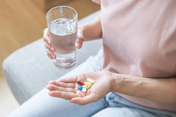 Sick, asian young woman, girl hand holding pill capsule, painkiller medicine from stomach pain,...