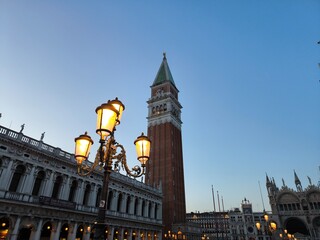 Fototapeta na wymiar Venice, bell tower of Piazza San Marco at sunset with street lamps
