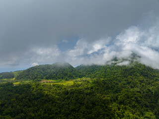 Fototapeta na wymiar Fogs over the mountain slopes with rainforest in Camiguin Island. Philippines.