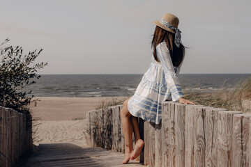 pregnant woman in hat sitting near the beach