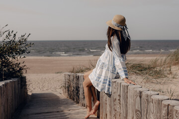 pregnant woman in hat sitting near the beach