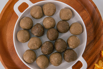 Fresh home made urad dal and millet laddu isolated and decorated. Locally called Urad Dal Ladoo, Ulundu urundan, Ulundu laddu, Kambu laddu. Selective focused millet ladoo.