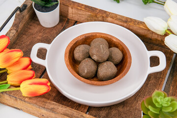Fresh home made urad dal and millet laddu isolated and decorated. Locally called Urad Dal Ladoo, Ulundu urundan, Ulundu laddu, Kambu laddu. Selective focused millet ladoo.
