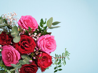 Card with a bouquet of pink and red roses on light blue background. Place for Your Text