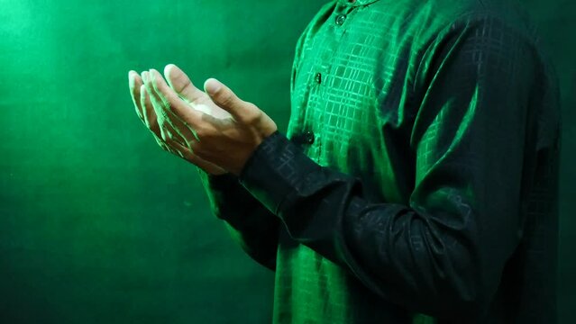 The intimate moment of a Muslim man's hands clasped in prayer during Ramadan