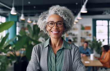 Smiling afro american middle age woman, radiating positivity and confidence in a stylish workplace setting. - Powered by Adobe