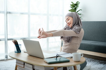Young business Asian Business muslim woman in hijab using a tablet, Sitting near the window in the...