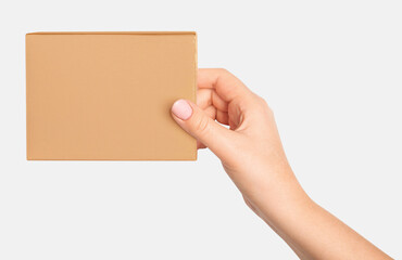 Woman's hand holding a cardboard box on a light background