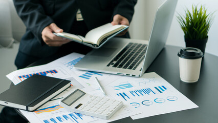 Close-up of businesswoman accountant using calculator and laptop, financial documents to analyze...