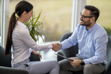 Real estate agent with woman closing a deal and signing a contract