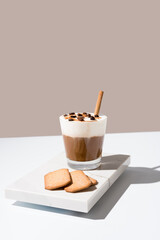 Café vienés con crema batida y canela sobre mármol en un fondo beige	