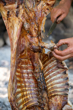 Grilled Lamb, traditional way of cooking sheep meat in Argentina. Cutting it and serving it from the grill.
