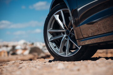 Close-up view of wheel of sports car at the gravel road