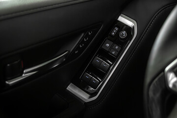 close-up of the side door buttons: window adjustment buttons, door lock.
