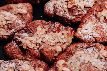 Sweet freshly baked croissants with almonds and powdered sugar. Delicious dessert