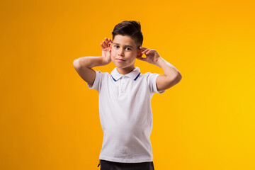 Kid boy eavesdropping, overhearing confidential secret conversation, keeping hand at his ear....