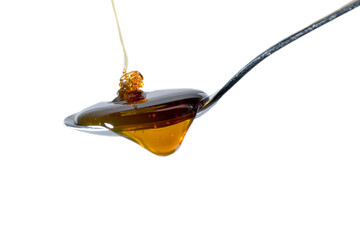 Honey flows onto a full teaspoon and begins to run off the spoon. isolated on transparent background