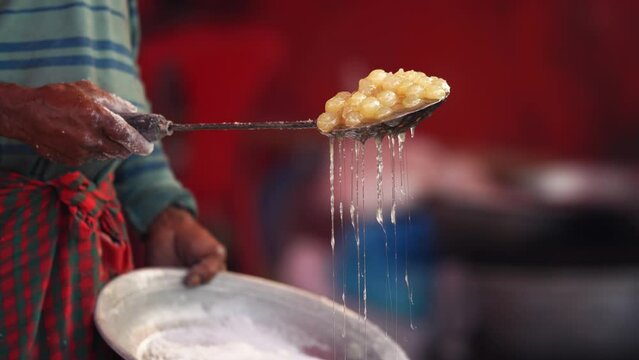 Art of making Rasgulla, a delightful Indian dessert made from milk solids, deep-fried to golden perfection and soaked in fragrant sugar syrup. Vibrant, aromatic, tempting. A feast for the senses