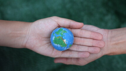 Environment Earth Day In the hands holding green earth on Bokeh green Background, Saving environment, and environmentally sustainable. Save Earth. Concept of the Environment World Earth Day