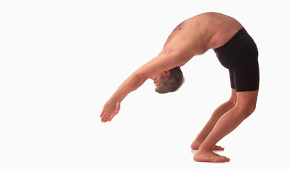 Ashtanga yoga  Side view of man wearing sportswear doing Yoga exercise against white background....