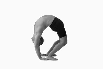 Triangle Pose Yoga (Utthita Trikonasana), Ashtanga yoga  Side view of man wearing sportswear doing Yoga exercise against white background. Black and white image.