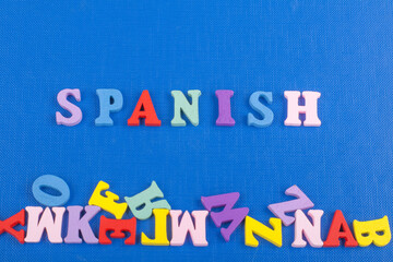 SPANISH word on blue background composed from colorful abc alphabet block wooden letters, copy space for ad text. Learning english concept.