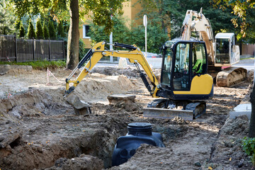 Laying underground communications in the ground during road repairs. Repair construction site with...