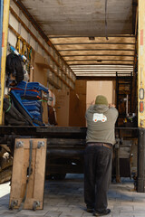 worker loading a box onto a moving truck, horizontal