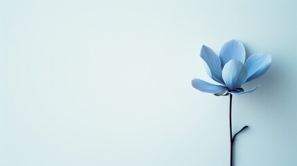 a single blue flower sitting on top of a blue wall next to a blue vase with a flower in it.