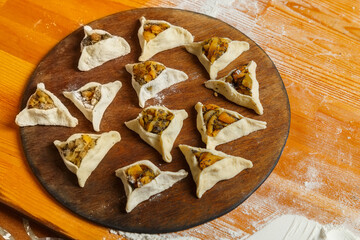 Sweet fashioned gomentashi cookies laid on a wooden board.
