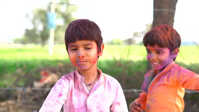 Indian little kids celebrating holi festival. Dancing and playing holi colours