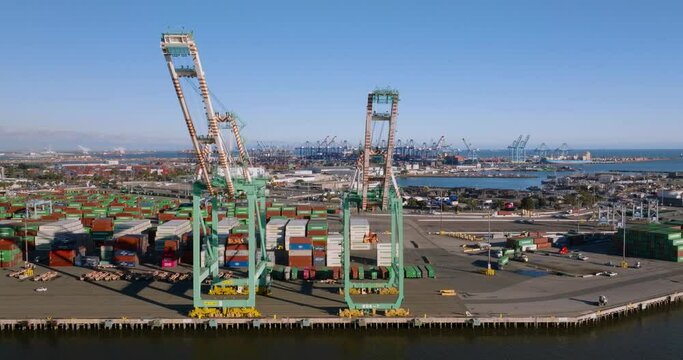 panning view of cranes for loading ships in large container port