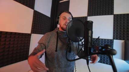 Vocal Recording Session in Sound Studio, An aspiring male vocalist recording music in a soundproof studio with professional audio equipment