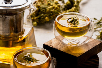 Glass of tea or herbal tea on white stone background
