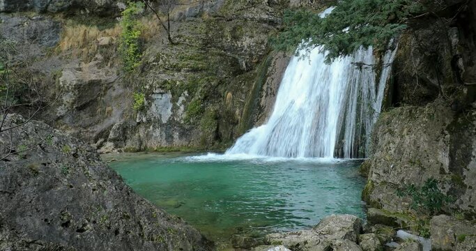 Beautiful waterfall over blue lake at the source of the Mundo River, Riopar, Albacete, Castilla la Mancha, Spain
