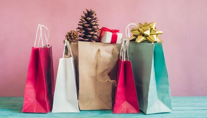 christmas gifts in shopping bags on a pink background pastel colors holiday concept