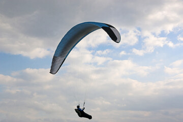 Paraglider flying in a cloudy sky	